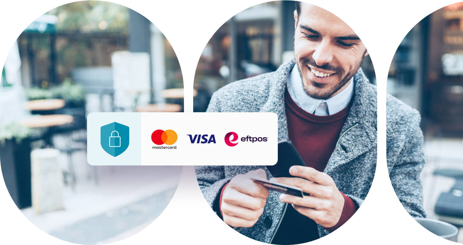 Man holding a mobile phone and credit card that could be a Visa or Mastercard.