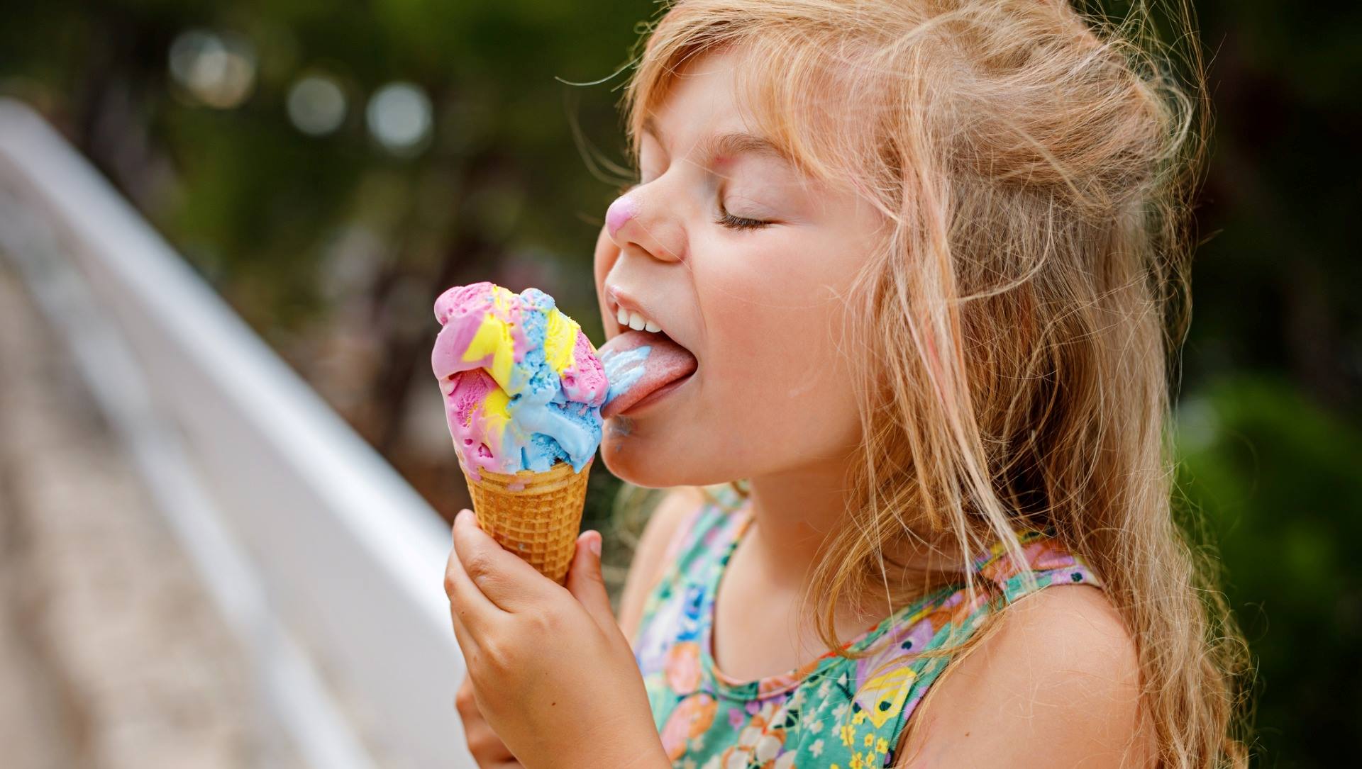 Young girl eating colourful ice cream cone on sunny summer day - Cashrewards.jpg