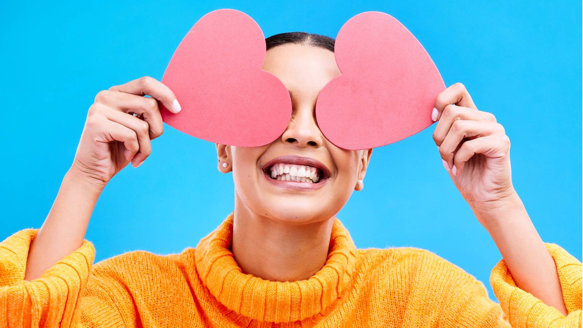 Woman smiling carrying heart-shaped cards