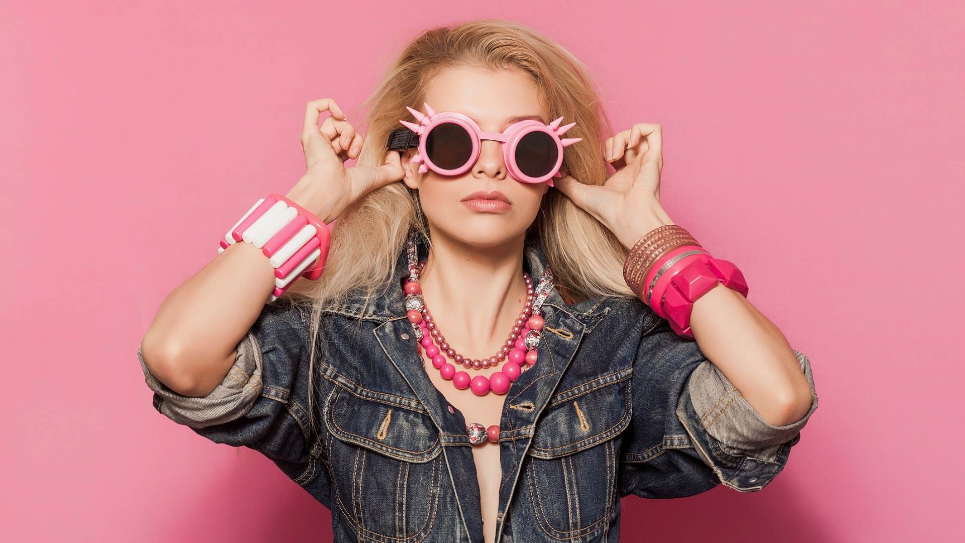 Blond woman wearing denim jacket and pink fashion accessories