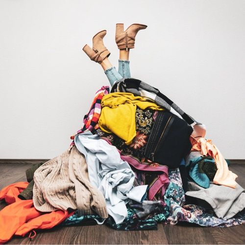 woman legs out of a pile of clothes on the floor